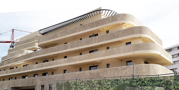Vue d’ensemble de la résidence accueil de Lattes et de ses étages aux balcons arrondis, sous un pare-soleil courbe